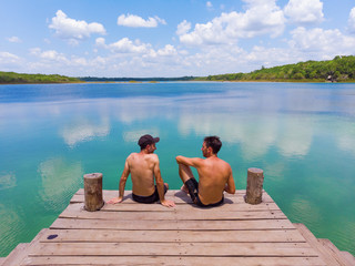 Two friends sitting by a freshwater lagoon, Mexico