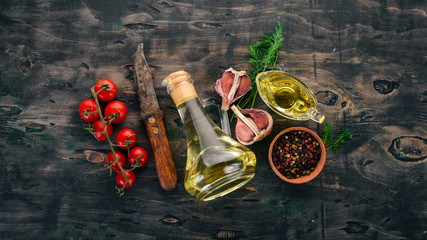 Oil in a glass jar. Olive oil. Top view. On a black wooden background. Free space for text.