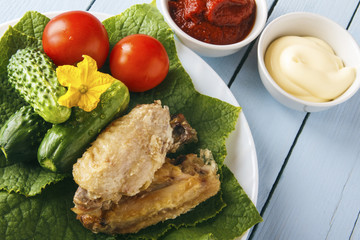 Dietary food from chicken wings and natural organic vegetables. Tomato paste and mayonnaise on wooden table. Copy space