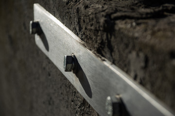 Old screw on construction cement wall. Iron bolt in a concrete wall.