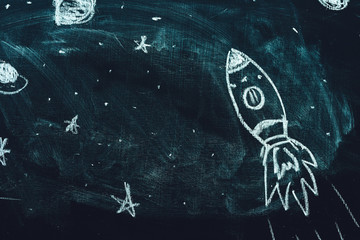 Space rocket doodle drawing on chalkboard
