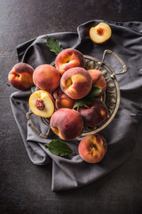 A group a ripe peaches in rustic bowl