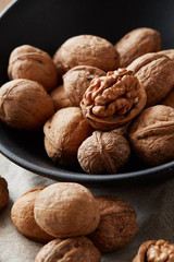 Walnuts and kernels with burlap fabric on a dark rusty wood backdrop