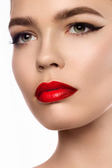 Close up portrait of beautiful young model with professional makeup, perfect skin. Trendy eyelines and red lips. Shiny eyelines