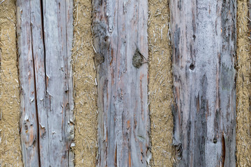 Old wooden home wall background, log house with clay seal close up