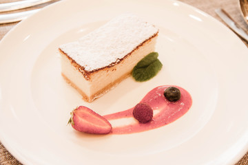 Traditional polish cheesecake served with fruit and sauce