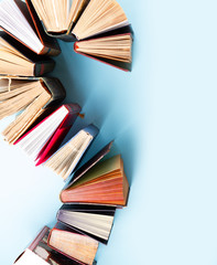 Curve of old books on plain blue background with copy space