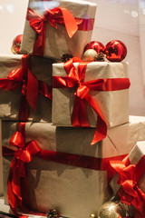 stylish craft gift boxes with red ribbons in window shop, seasonal holiday present concept