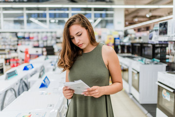 Beautiful young woman reading a brochure.