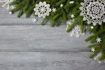 Christmas wooden background with spruce branches and lacy snowflakes