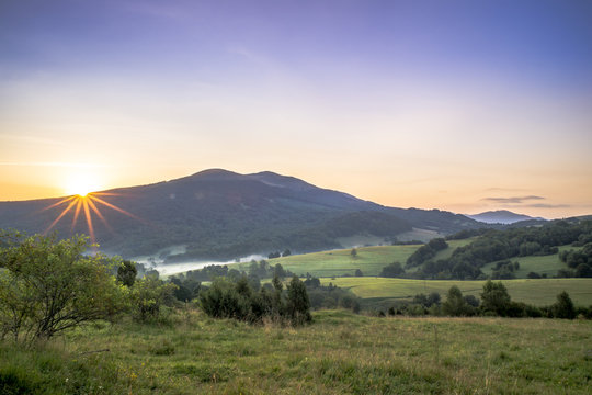 Fototapeta Połonina Caryńska w Bieszczadach o wschodzie słońca. Widok z przełęczy Wyżnej. W oddali Tarnica