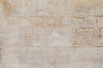 Old yellow scratched brick wall in Spain. Texture of bricks 