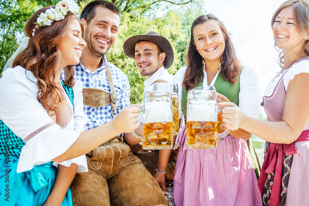 Wall mural Freunde Trinken Bier in der Bayerischer Tracht an der Isar