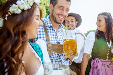 Freunde Trinken Bier in der Bayerischer Tracht an der Isar