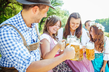 Freunde Trinken Bier in der Bayerischer Tracht an der Isar