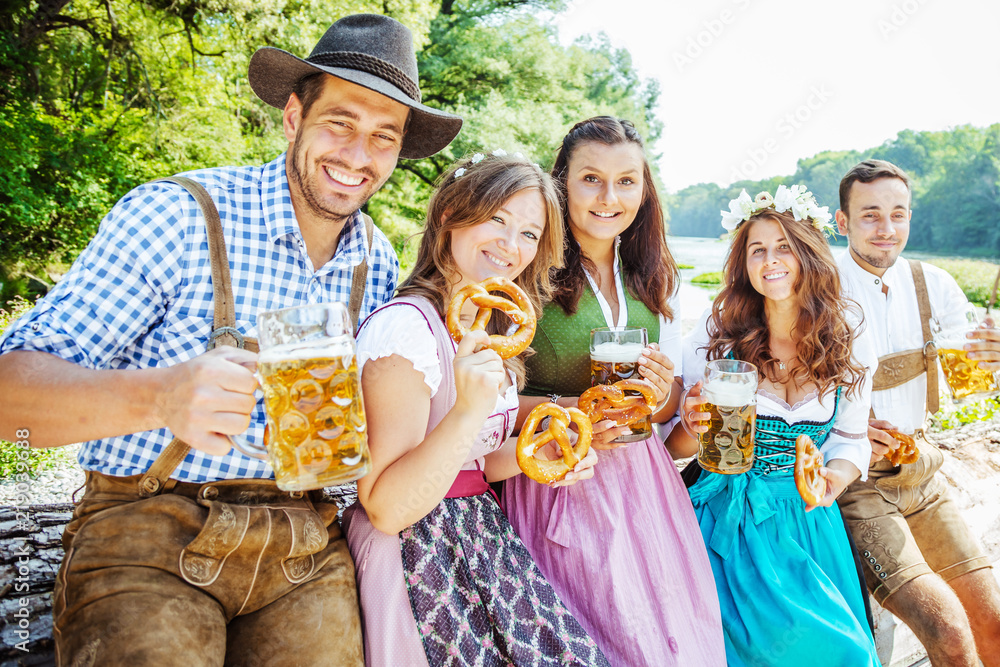 Wall mural Freunde Trinken Bier in der Bayerischer Tracht an der Isar