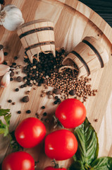 Spices: chili, black pepper, garlic, cumin, coriander, sweet pepper lie on a brown round wooden board on a black table. Place under the text.