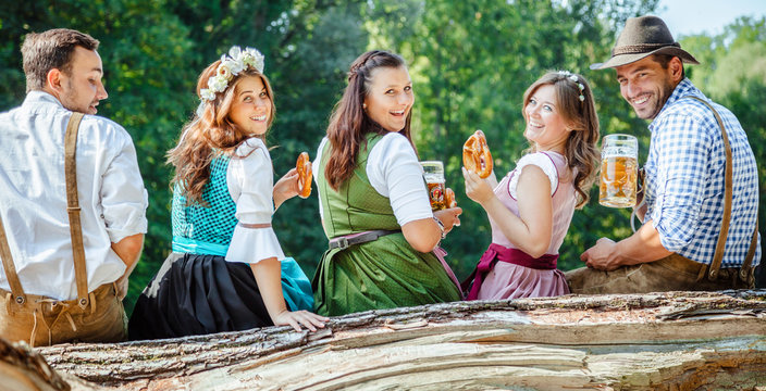 Freunde Trinken Bier in der Bayerischer Tracht an der Isar
