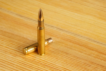 Cartridges for a rifle  on a wooden background