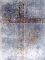 Cross of seams on grey rust metal surface