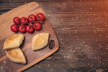 fresh tasty bun set with tomatoes on wood;