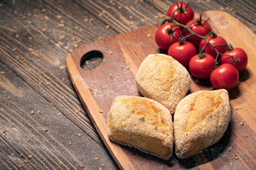 fresh tasty bun set with tomatoes on wood;