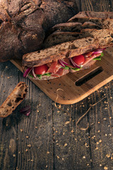 top view of fresh sandwich with tomato and ham on wood;