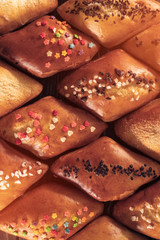 top view of fresh sweet baked buns set on wood;