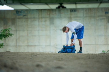 Young man packs his bag before his workout