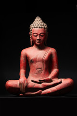 The statue of red Buddha, in Southeast Asia style. Isolated on black background.