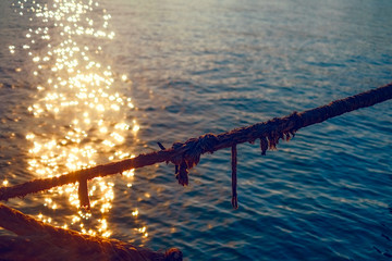 hawser rope hanging over the water with glowing sunshine