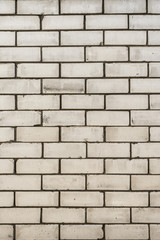 texture of a wall from a natural white brick with small cracks and chips, close-up abstract background