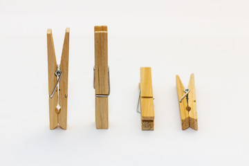 Isolated wooden clothes pegs standing and lying side by side on a white background