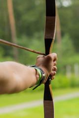 Aiming archers hand on the green background.