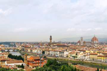 Fototapeta na wymiar Top panoramic view of old town Florence city, riverside of Arno river, Ponte vecchio bridge and Cathedral of Santa Maria del Fiore during and cloudy sky from Piazzale Michelangelo in Florence, Italy.