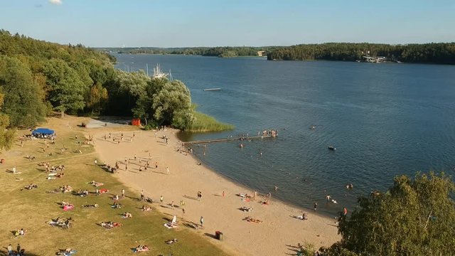 A beach in Stockholm at afternoon with several people, who are enjoying the summer.