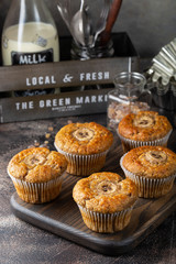 Banana muffins with cinnamon on chopping wooden board