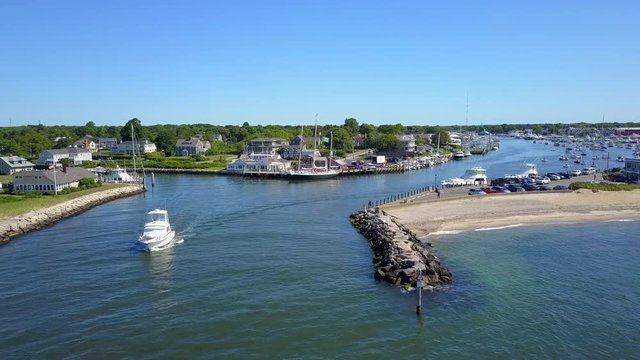 A Large Boat Makes its way out of Falmouth Harbor in Massachusetts on a Beautiful Day, Aerial Approach Shot