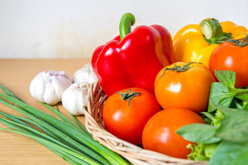 Organic vegetables in the wicker basket on wooden background