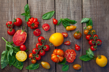  fresh organic colorful tomatoes on wooden surface