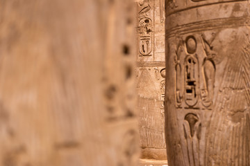 Stone Columns wall with Egyptian carving figures and hieroglyphs, Aswan, Egypt.