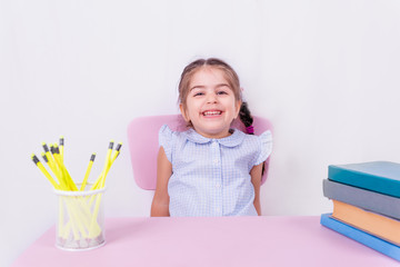 Portrait of cute little happy girl in school uniform