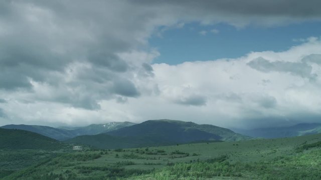 Time lapse of white clouds moving over mountains