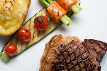 Close up Hida beef steak with grilled tomato, carrot, cucumber and asparagus on white plate