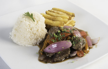 Peruvian food lomo saltado :A salted beef with tomatoes, onion, fried potatoes and rice.