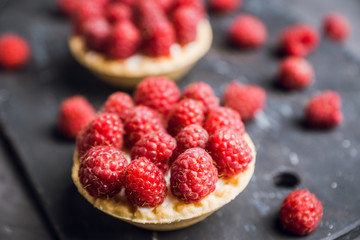 Rasberry cake decorated with fresh ripe berries on the rustic background. Selective focus. Shallow depth of field.