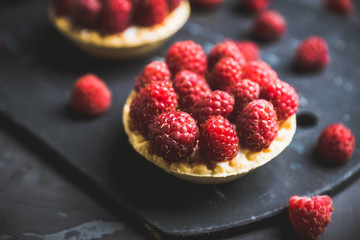 Rasberry cake decorated with fresh ripe berries on the rustic background. Selective focus. Shallow depth of field.
