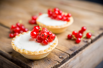 Red currant cake decorated with fresh ripe berries on the rustic background. Selective focus. Shallow depth of field.