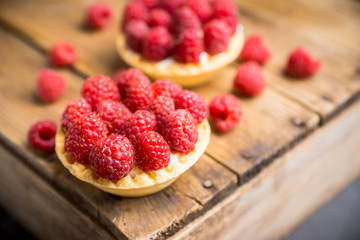 Rasberry cake decorated with fresh ripe berries on the rustic background. Selective focus. Shallow depth of field.