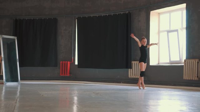 Pretty gymnast performing balance exercises in gym